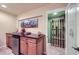 Basement bar with granite countertop, cabinetry and small refrigerator, with temperature controlled wine cellar at 10984 Alcott Dr, Denver, CO 80234