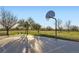 Community basketball court on a sunny day, surrounded by grass, trees, and walking paths at 10984 Alcott Dr, Denver, CO 80234