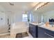 Well-lit bathroom with a bathtub, glass shower and double vanity at 10984 Alcott Dr, Denver, CO 80234