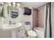 Cozy bathroom featuring a pedestal sink, cabinet storage, and shower and tub with tile surround at 10984 Alcott Dr, Denver, CO 80234
