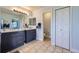 Bright bathroom with double vanity, neutral tile floor and a linen closet at 10984 Alcott Dr, Denver, CO 80234