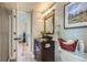 A well-lit bathroom with a dark wood vanity, granite countertop and view into hallway at 10984 Alcott Dr, Denver, CO 80234