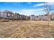 A large backyard area sits behind modern townhomes, awaiting landscaping and outdoor activities at 2876 W 53Rd Ave # 122, Denver, CO 80221