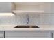 Close up of modern stainless steel sink and faucet with a geometric backsplash design at 2876 W 53Rd Ave # 122, Denver, CO 80221