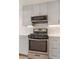 Close up of stainless steel oven, microwave, and sleek cabinetry with unique backsplash at 2876 W 53Rd Ave # 122, Denver, CO 80221
