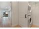 Modern laundry room featuring a stacked washer/dryer and an open doorway to the home's balcony at 2876 W 53Rd Ave # 122, Denver, CO 80221