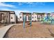 Modern townhomes next to a playground with swings and other playground equipment at 2876 W 53Rd Ave # 122, Denver, CO 80221