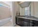 Bathroom featuring a granite countertop vanity, mirror, and shower-tub combination at 14997 Elsinore Ave, Parker, CO 80134