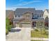 Beautiful two-story home featuring a stone facade, three-car garage, and manicured front lawn at 14997 Elsinore Ave, Parker, CO 80134