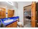 Bathroom featuring blue tile countertops and wood cabinets with a view to living space at 683 Ridgemont Cir, Highlands Ranch, CO 80126