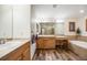 Bright bathroom featuring dual sinks, soaking tub, wood-look floors and lots of counter space at 683 Ridgemont Cir, Highlands Ranch, CO 80126