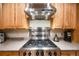 Close-up of the kitchen with a stainless steel vent hood and professional-grade cooktop at 683 Ridgemont Cir, Highlands Ranch, CO 80126