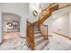 Elegant curved staircase with wooden banister and marble floors at 683 Ridgemont Cir, Highlands Ranch, CO 80126
