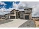 Contemporary home with stone and wood siding, a spacious driveway, and attached two-car garages at 5926 Hickory Oaks Trl, Castle Rock, CO 80104