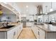 Spacious gourmet kitchen with white cabinetry, large island, stainless appliances, and granite countertops at 10622 Van Gordon Way, Broomfield, CO 80021