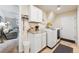 Well-lit laundry room with modern appliances, storage cabinets, and access to the living room at 10622 Van Gordon Way, Broomfield, CO 80021