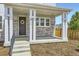 Welcoming front porch with stone accents, decorative wreath, and elegant white columns at 9111 W 100Th Way, Broomfield, CO 80021