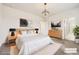 Staged main bedroom with a chandelier, neutral colors, and a view to the bathroom at 9111 W 100Th Way, Westminster, CO 80021