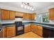 Cozy kitchen featuring wood cabinets, black appliances, and ample counter space at 18508 E Whitaker Cir # D, Aurora, CO 80015