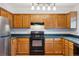 Cozy kitchen featuring wood cabinets, updated appliances, and modern lighting at 18508 E Whitaker Cir # D, Aurora, CO 80015