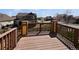 A view from the wooden back deck shows manicured lawn and charming neighborhood with mature trees at 8632 Yule St, Arvada, CO 80007