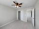 Neutral bedroom featuring a ceiling fan, closet, and a doorway to another room at 8632 Yule St, Arvada, CO 80007