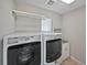 Modern laundry room equipped with a washer, dryer, and storage shelving at 8632 Yule St, Arvada, CO 80007