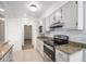 Kitchen with black appliances, granite countertops, and white cabinets at 1625 Larimer St # 1001, Denver, CO 80202