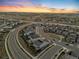 An aerial view showcases the community's design amidst the open landscape during a picturesque sunset at 18014 Tree Sparrow Ave, Parker, CO 80134