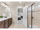 Open ensuite bathroom with granite counters, double sinks, tiled shower and tile floors at 18014 Tree Sparrow Ave, Parker, CO 80134