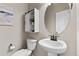 Powder bath features a pedestal sink, round mirror, modern fixtures and storage at 18014 Tree Sparrow Ave, Parker, CO 80134