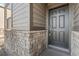 Close up of a home's front door framed by stone veneer and matching trim at 18014 Tree Sparrow Ave, Parker, CO 80134