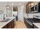 Open kitchen offers wood floors, granite countertops, stainless appliances, and modern subway tile at 18014 Tree Sparrow Ave, Parker, CO 80134