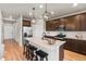 An open concept kitchen boasts stainless appliances, wood floors, granite counters, and dark cabinets at 18014 Tree Sparrow Ave, Parker, CO 80134