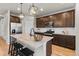 Open kitchen features stainless appliances, wood floors, granite counters, and dark cabinets at 18014 Tree Sparrow Ave, Parker, CO 80134