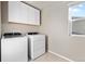 Laundry room features washer, dryer, storage cabinets, and a window for natural light at 18014 Tree Sparrow Ave, Parker, CO 80134
