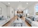 Spacious living room flowing into the dining area and kitchen, with hardwood floors throughout at 18014 Tree Sparrow Ave, Parker, CO 80134