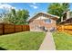 Well-maintained backyard with lush grass, wood fence, and seating area at 900 Jackson St, Denver, CO 80206