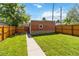 Lush green backyard featuring a long walkway, wooden fence, and garden space at 900 Jackson St, Denver, CO 80206