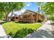 Inviting brick home featuring a lush green lawn and mature trees at 900 Jackson St, Denver, CO 80206