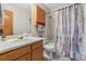 This bathroom offers a shower and bath combination, toilet, and wood cabinetry at 180 S Carlton St, Castle Rock, CO 80104