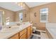 Bright bathroom with double sinks, a large mirror, and separate tub and shower at 180 S Carlton St, Castle Rock, CO 80104