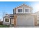 Charming two-story home featuring gray siding, brick accents, and a two-car garage at 180 S Carlton St, Castle Rock, CO 80104