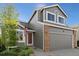 Well-maintained home exterior features a two-car garage and brick accents at 180 S Carlton St, Castle Rock, CO 80104