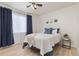 Inviting bedroom with natural light, neutral walls, ceiling fan, and a comfortable bed with blue accents at 5537 Lewis Ct # 1, Arvada, CO 80002