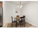 Bright dining area features a modern chandelier, wood table, seating for four, and adjacent stainless refrigerator at 5537 Lewis Ct # 1, Arvada, CO 80002