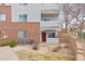 A condo with brick and gray siding, a red front door, and a small porch with stone landscaping at 5537 Lewis Ct # 1, Arvada, CO 80002
