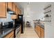 A kitchen with wood cabinets, black countertops, and stainless steel appliances at 5537 Lewis Ct # 1, Arvada, CO 80002