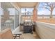 A condo porch features a stainless steel grill, a red brick support column and concrete flooring at 5537 Lewis Ct # 1, Arvada, CO 80002