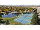 Aerial shot of community tennis courts, a pond, and mature trees at 3076 W 112Th Ct # C, Westminster, CO 80031